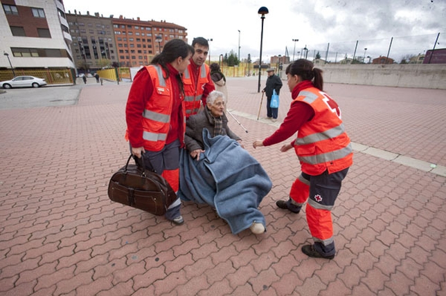 La labor de voluntarios y fuerzas de seguridad y sanitarias fue encomiable. En la imagen, una persona en silla de ruedas desalojada de su hogar llega al Talamillo con ayuda de Cruz Roja.  / VALDIVIELSO