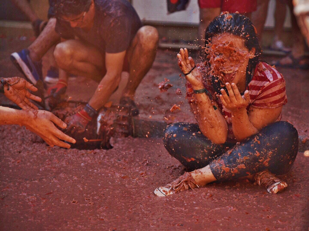 Un joven se mancha con los restos de los tomates arrojados durante la fiesta de la Tomatina de Buñol 2019.   / JORGE GIL