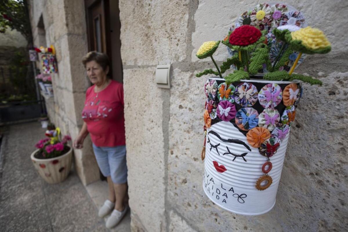 Pilar ha pasado el invierno decorando latas y tejiendo sus flores de ganchillo para ofrecer una fachada así de colorida.   / LUIS LÓPEZ ARAICO