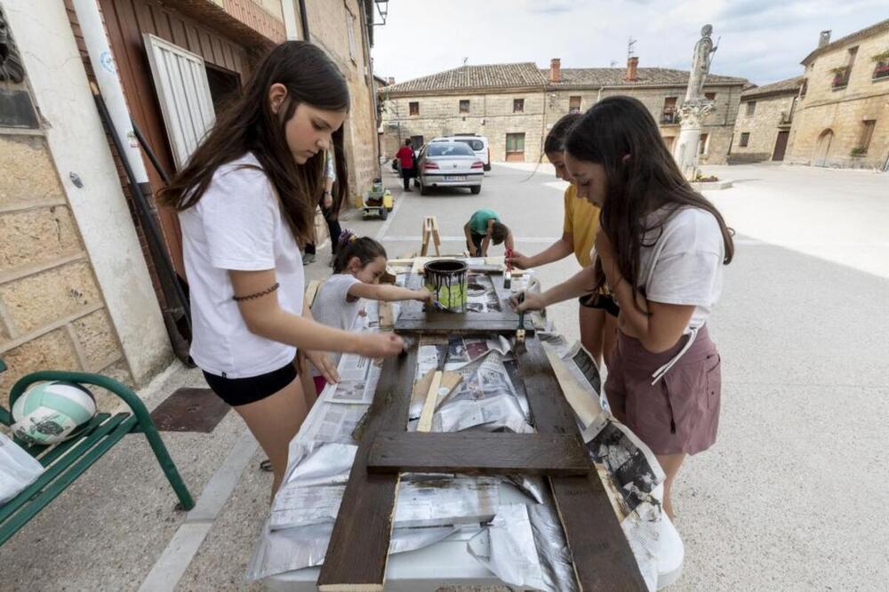 Las niñas aprovechan el buen tiempo para salir a la calle a pintar los decorados.