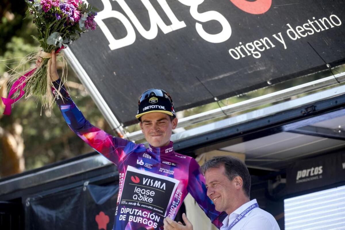 Sepp Kuss, feliz en el podium tras ganar en Nelia y enfundarse el maillot morado de líder de la general.    / VALDIVIELSO