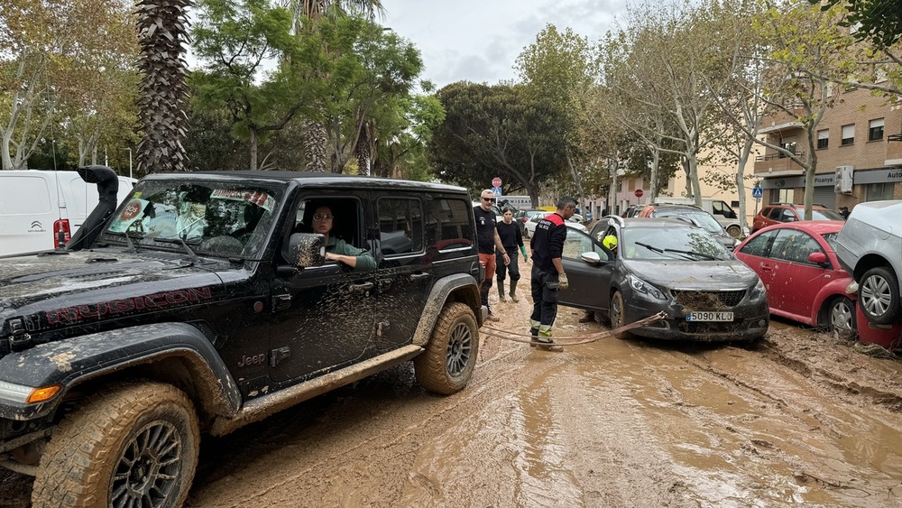 Cristina Gutiérrez ayuda a remolcar un coche con su 4x4 en una de las localidades afectadas por la DANA.