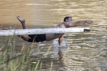 Acrobacias sobre el río a cambio de dinero